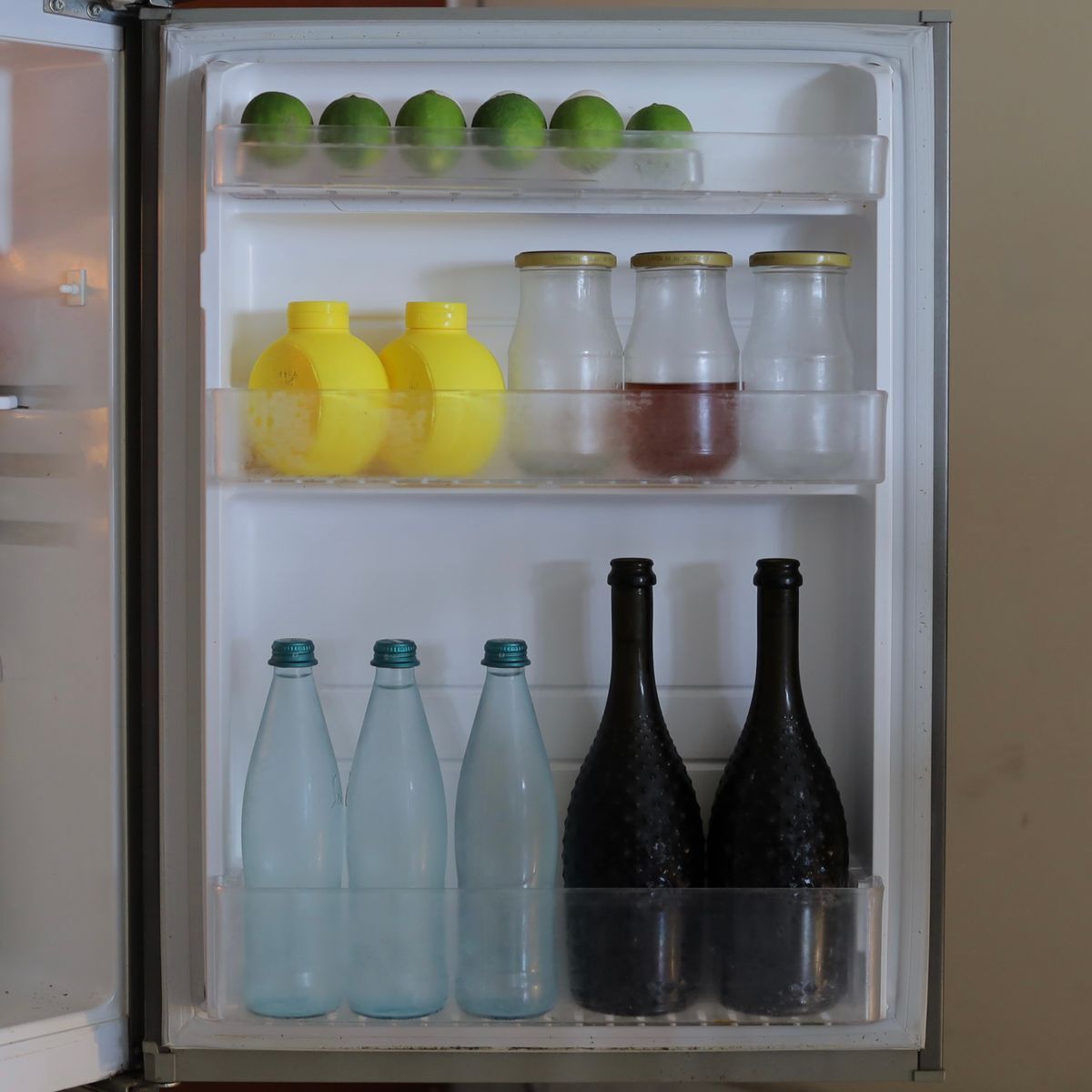 Open refrigerator stocked with bottles and fresh food
