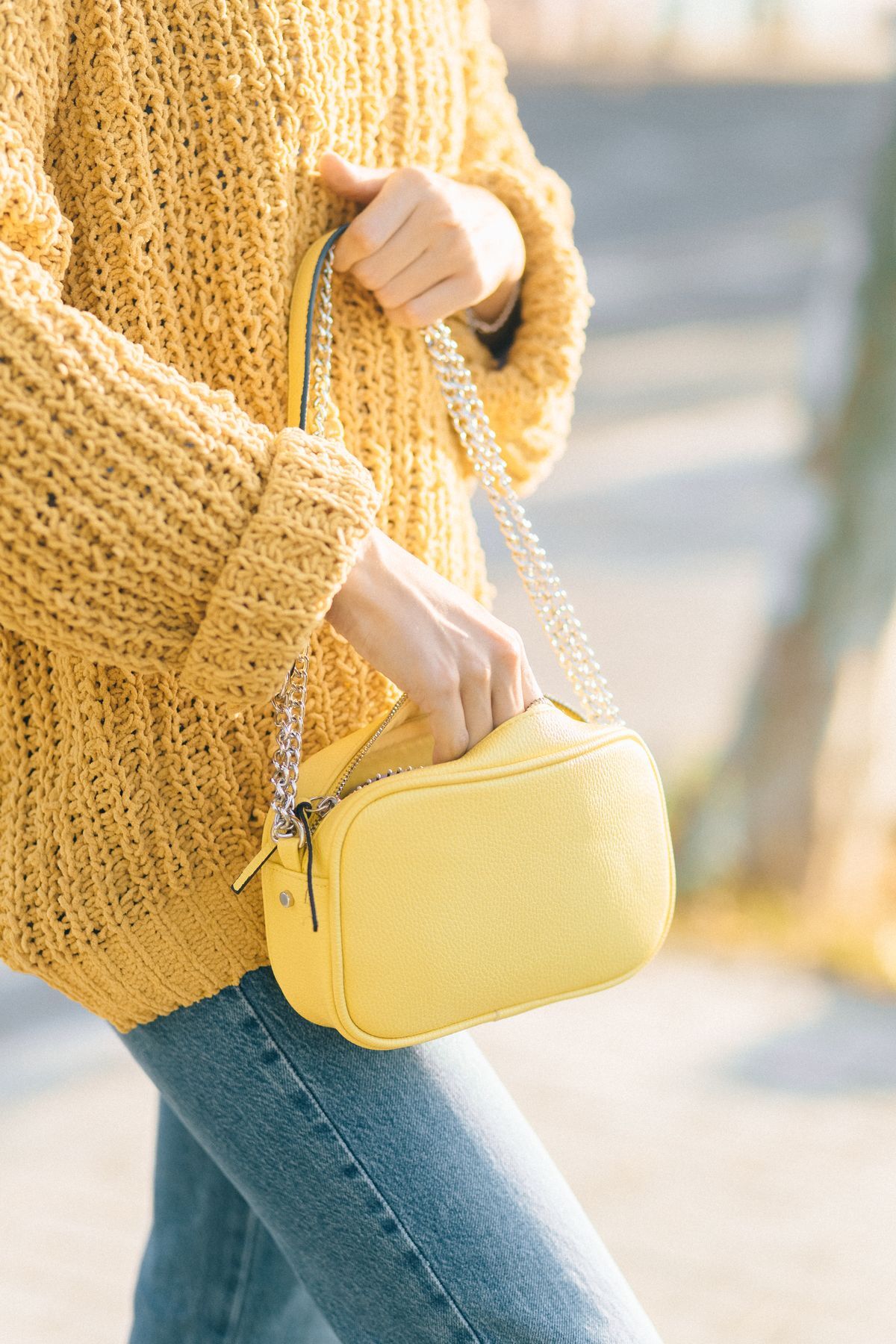 Person carrying a bright yellow handbag on their shoulder