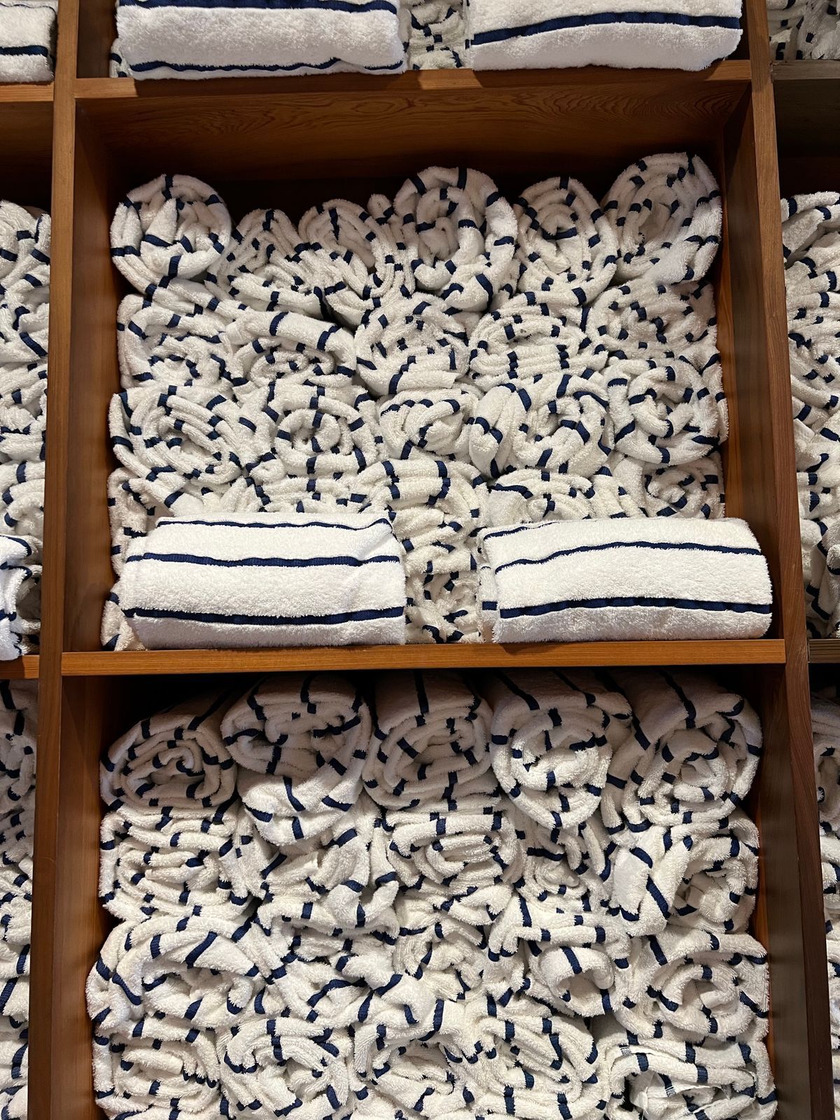 Housekeeping shelves stacked with folded towels and linen