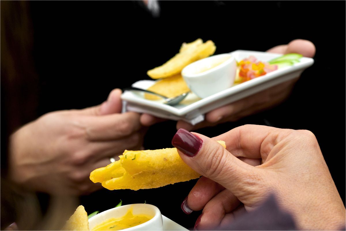 Waiter's hands passing plated food during service
